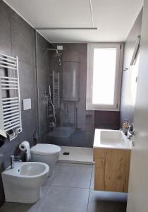 y baño con aseo, lavabo y ducha. en Dainese Apartments, Casa Miriam, en Lido di Jesolo