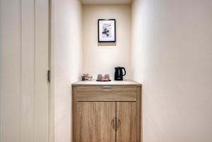 a small wooden cabinet with a coffee maker on top at Luxury Studio Rooms, Stockton, Pet Friendly, Wifi in Stockton +11 photos