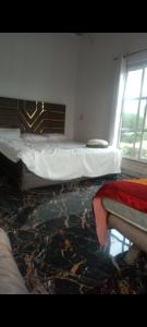 a bedroom with two beds and a window at Sun n moon farm in Noida