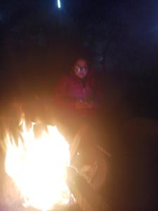 une personne debout devant un incendie la nuit dans l'établissement Sun n moon farm, à Noida