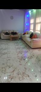 Sala de estar con 2 sofás y mesa en Sun n moon farm, en Noida
