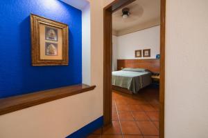 um quarto com uma parede azul e uma cama em Hotel Suites Del Centro em Oaxaca City