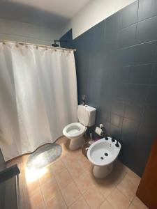 ein Badezimmer mit einem weißen WC und einem Waschbecken in der Unterkunft Departamentos PRANA in Villa Mercedes