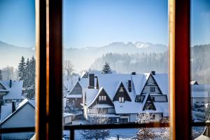 a view of a snowy village from a window at U Cudzicha in Zakopane