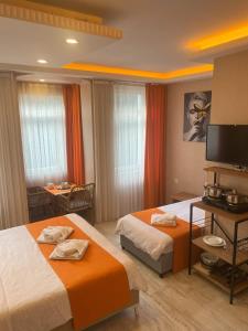 ein Hotelzimmer mit 2 Betten und einem TV in der Unterkunft AURA HOTEL in Istanbul