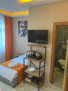ein Hotelzimmer mit einem Bett und einem Flachbild-TV in der Unterkunft AURA HOTEL in Istanbul