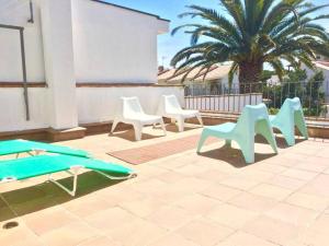 a group of chairs and a surfboard on a patio at Maison Palamos La Fosca in Palamós