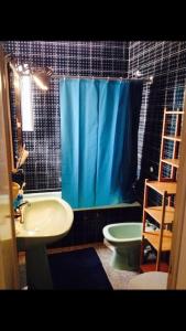 a bathroom with a sink toilet and a blue shower curtain at Maison Palamos La Fosca in Palamós +14 photos