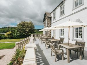 an outdoor patio with tables and umbrellas at Cartmel Old Grammar in Cartmel