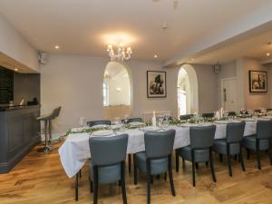 a dining room with a long table and chairs at Cartmel Old Grammar in Cartmel