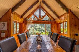 a dining room with a long wooden table and chairs at Ballots Bay Treehouse by Host Agents in George
