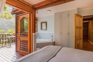 a bedroom with a bed and a tub at Ballots Bay Treehouse by Host Agents in George