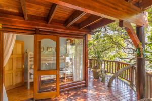 a wooden porch with glass doors on a deck at Ballots Bay Treehouse by Host Agents in George