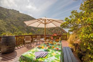 a table with food and an umbrella on a deck at Ballots Bay Treehouse by HostAgents in George