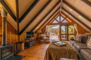 a living room with a couch and a fireplace at Ballots Bay Treehouse by HostAgents in George