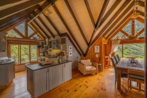 a large kitchen with wooden ceilings and a dining room at Ballots Bay Treehouse by Host Agents in George