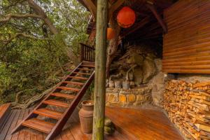 a wooden staircase leading to a cabin with a tree at Ballots Bay Treehouse by Host Agents in George