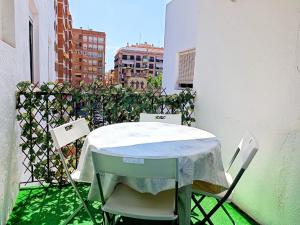 een tafel en stoelen op een balkon met een hek bij Apartamento Caracola con AA y Wi-Fi cerca del mar in Vinarós