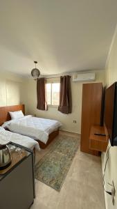 Habitación de hotel con 2 camas y TV en ALADDIN PYRAMIDS CITY, en El Cairo