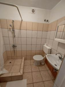 a bathroom with a toilet and a sink at Pokoje Gościnne u Kasi in Międzywodzie