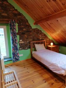 ein Schlafzimmer mit einem Bett und einer Steinmauer in der Unterkunft Gite de caractère rural in Bastogne