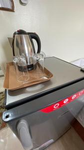 a tea kettle and glasses on top of a appliance at ALADDIN PYRAMIDS CITY in Cairo