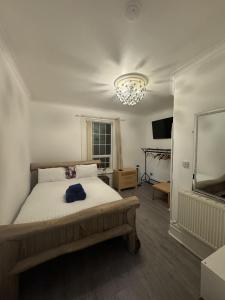 a bedroom with a large bed and a chandelier at Valencia in Blackpool