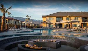 einem Pool mit einer Feuerstelle vor einem Gebäude in der Unterkunft Zion Village Poolhouse in Hurricane with Pool and Hot Tub in Hurricane