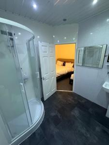 ein Bad mit einer Dusche und ein Schlafzimmer mit einem Bett in der Unterkunft Valencia in Blackpool
