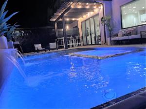 duży niebieski basen z wodospadem w budynku w obiekcie 29-30 | 2 Connected Homes in Ocotillo Springs with Pool and Spas w mieście Santa Clara