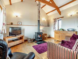 a living room with a fireplace and a tv at 1 Bed in Polperro OVERH in Lansallos
