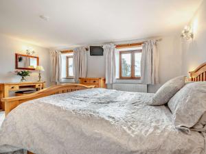 a bedroom with a large white bed and windows at 1 Bed in Polperro OVERH in Lansallos