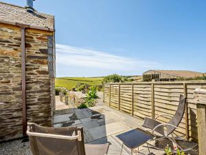 a patio with two chairs and a fence at 1 Bed in Polperro OVERH in Lansallos