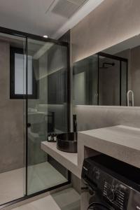 a bathroom with a sink and a glass shower at No Stars - Luxury Hotel Apartments in Ioannina