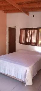 sypialnia z białym łóżkiem i oknem w obiekcie Shajar 2 w mieście Villa Gesell