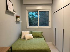 a green couch in a room with a window at Cantinho da Paty in Florianópolis +24 photos