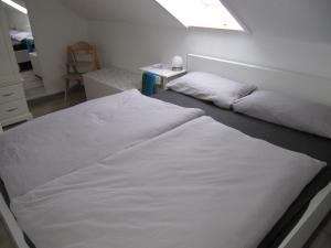 two white beds in a room with a window at Sperrentalblick in Sankt Andreasberg