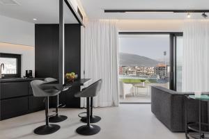 una cucina e un soggiorno con tavolo e sedie di No Stars - Luxury Hotel Apartments a Ioannina