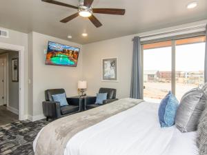 a bedroom with a bed and two chairs and a window at Sage Creek E1 in Moab with Scenic Community Pool in Moab