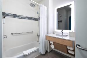 a white bathroom with a tub and a sink at EVEN Hotel Miami - Airport, an IHG Hotel in Miami