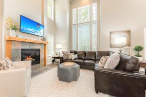 sala de estar con sofá de cuero y chimenea en Union Duplex Woods and Spruces in Salt Lake with Hot Tub, en Midvale