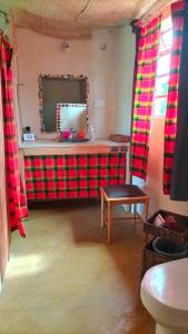 a bathroom with a mirror and a table and a stool at Beats Of Beads Trust in Masai Mara