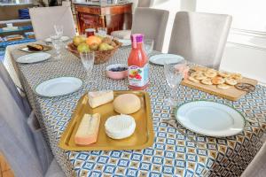 een tafel met kaas en andere voedingsmiddelen bij Charming large house in Courbevoie - Welkeys in Courbevoie