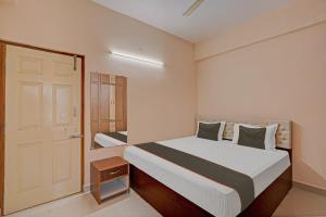 a small bedroom with a bed and a door at Collection O Ns Service Apartment in Tirupati