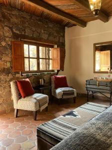 a living room with two chairs and a mirror at Hotel Amor y Paz in Real de Catorce