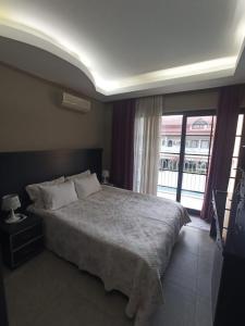 a bedroom with a large bed and a large window at Ölüdeniz Günlük, haftalık ve aylık apart. in Fethiye