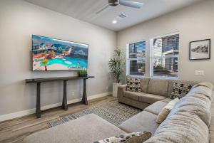 a living room with a couch and a flat screen tv at 13| Red Mountain View in St. George with Private Hot Tub in Santa Clara