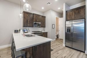 a kitchen with wooden cabinets and a stainless steel refrigerator at 13| Red Mountain View in St. George with Private Hot Tub in Santa Clara