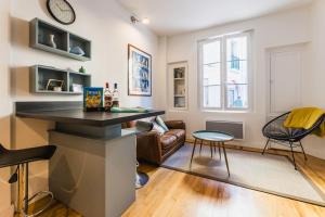 een keuken en een woonkamer met een aanrecht en stoelen bij MAITALEA KEYWEEK Quiet downtown apartment in Biarritz
