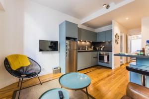 een keuken met blauwe kasten en een tafel en stoelen bij MAITALEA KEYWEEK Quiet downtown apartment in Biarritz